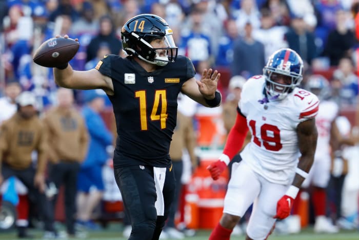 Washington Commanders quarterback Sam Howell (14) passes the ball as New York Giants wide receiver Isaiah Hodgins (18) chases during the fourth quarter at FedExField.